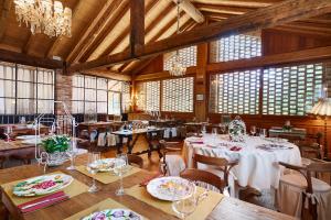 a dining room with tables and chairs and windows at Locanda Sandi in Valdobbiadene