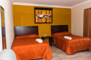 a hotel room with two beds with orange sheets at Terracota Corner Rooms in Campeche +132 photos