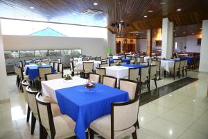 a dining room with tables and chairs with blue table cloth at Swamy Hotel in Cruzeiro do Sul