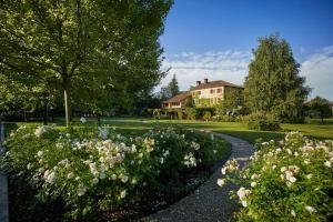 un giardino fiorito di fronte a una casa di Locanda Sandi a Valdobbiadene