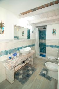 e bagno con lavandino, servizi igienici e doccia. di Sant'Anna Charming Apartments a Budoni