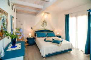 Schlafzimmer mit einem großen Bett und blauen Vorhängen in der Unterkunft Sant'Anna Charming Apartments in Budoni + 12 Fotos