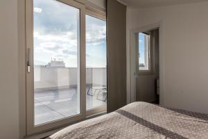 フォリーニョにあるIl Nido - Miniattico panoramico by AppartamentiPetrucciのベッドルーム1室(ベッド1台、大きな窓付)
