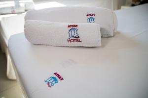una pila de toallas sentadas encima de una cama en Assay Plaza Hotel, en Hortolândia