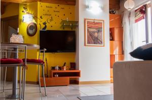 a living room with yellow walls and a flat screen tv at Romantic Home in Sondalo