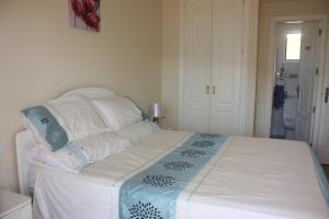 マニルバにあるAlboran Hills Holiday Appartmentのベッドルーム1室(白いベッドカバー、枕付)