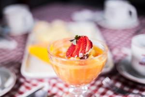 a dessert in a glass with a strawberry on top at Assay Plaza Hotel in Hortolândia