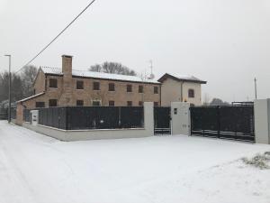 ein Haus mit einem Zaun im Schnee in der Unterkunft Casa Sansovino in Pontecasale