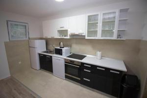 a kitchen with white appliances and black cabinets at Apartment Garden in Blagaj