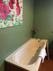 a bath tub in a bathroom with a painting on the wall at Chestnuts Bed and Breakfast in Whitehaven