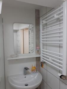 a white bathroom with a sink and a mirror at Super schöne Fewo in Aalen