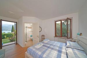 a bedroom with a bed and a large window at Villa Margherita Portese in San Felice del Benaco