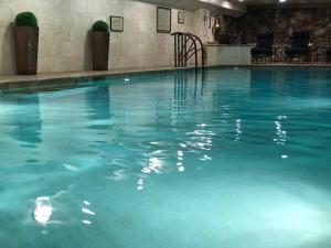 a large swimming pool with blue water in a hotel at Lewis & Clark Motel - Bozeman in Bozeman