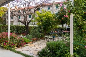 a garden with flowers and tables and chairs at APARTMENT JURAŠIN in Kaštela