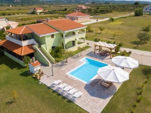 an aerial view of a house with a swimming pool and umbrellas at Three-Bedroom Apartment in Ljubac, Zadar I in Krneša