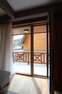 a room with a sliding glass door to a balcony at Lux Private Apartment Vučko in Jahorina