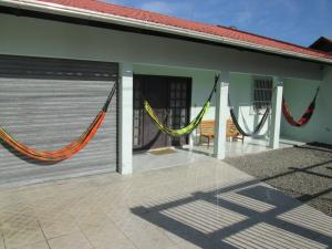 - un bâtiment avec des hamacs sur le côté dans l'établissement alugo esta linda e bem equipada casa em penha sc perto do beto carrero e da praia, à Penha