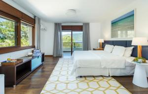 a hotel room with a bed and a desk and windows at Haute Haus - Guest House in Florianópolis