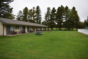 a house with a large yard with a picnic table at Country Club Motel in Old Forge