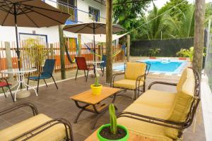 un patio con sillas y mesas y una piscina en Hacienda bambú en Bacalar