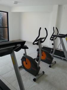 three exercise bikes in a room with a desk at Terraços da Barra Ap 106 in Barra de São Miguel