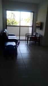 a living room with a couch and a window at Terraços da Barra Ap 106 in Barra de São Miguel