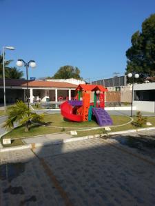 a playground with a slide in a parking lot at Terraços da Barra Ap 106 in Barra de São Miguel