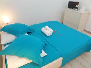 Una cama con sábanas azules y dos toallas. en Caraïbes Holidays en Sainte-Anne
