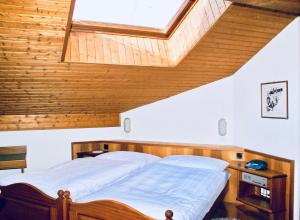 Schlafzimmer mit einem Holzbett und einem Dachfenster in der Unterkunft Hotel du Pont in Brig