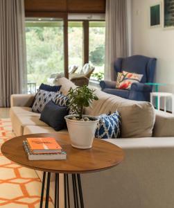 a living room with a couch and a table with a plant at Haute Haus - Guest House in Florianópolis