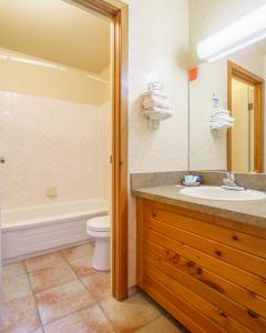 een badkamer met een wastafel, een bad en een toilet bij The Crossing in Saskatchewan River Crossing