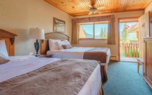 Una habitación de hotel con dos camas y una ventana. en The Crossing, en Saskatchewan River Crossing