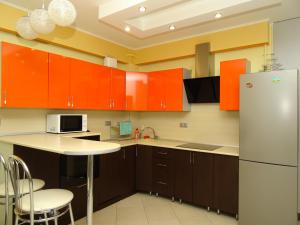 アドレルにあるКвартира в Адлереのキッチン(オレンジ色のキャビネット、白い冷蔵庫付)
