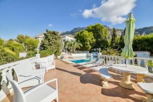 a patio with chairs and a table and a pool at Villa Esmeralda in Altea la Vieja