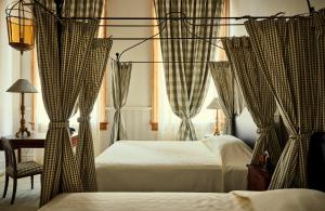 a bedroom with two beds and a desk and a window at Hotel Peter and Paul in New Orleans