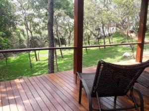 a porch with two chairs and a view of a yard at Pousada Santa Vila in Serra do Cipo