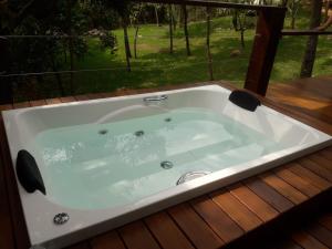 a bath tub sitting on a deck with a window at Pousada Santa Vila in Serra do Cipo