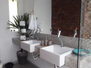 two white sinks in a bathroom with a mirror at Pousada Santa Vila in Serra do Cipo