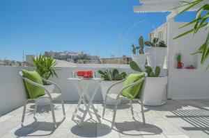 uma varanda com mesa, cadeiras e plantas em Adriani Hotel em Naxos Chora