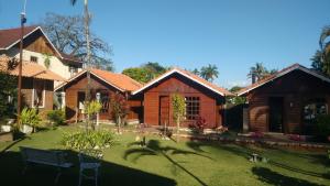 a house with a grass yard in front of it at Pousada Mon Desir in Penedo