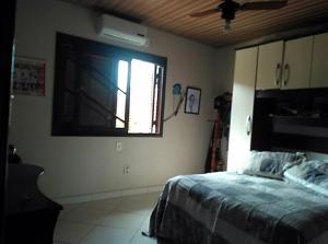 a bedroom with a bed and a window at Casa para temporada in Capão da Canoa