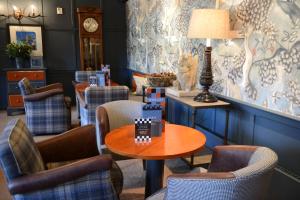 a room with a table and chairs and a clock at The Swan Hotel in Bibury