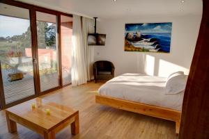 1 dormitorio con cama, mesa y ventana en Ruka Lobos en Pichilemu