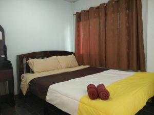 a bedroom with two beds with red slippers on them at Bansuan Inthanon Eco Resort in Chom Thong