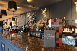 a bar with a counter with bottles of alcohol at The Swan Hotel in Bibury
