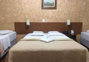 una camera con un letto con due cuscini sopra di Hotel Rafeli a Boituva