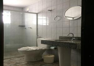 a bathroom with a toilet and a sink and a mirror at Hotel Rafeli in Boituva