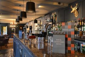 a bar with a counter with bottles of alcohol at The Swan Hotel in Bibury