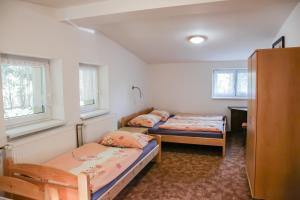 two beds in a small room with two windows at Chata Bajama in Bedřichov