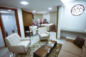 Piloes Palace Hotel في Mineiros: غرفة معيشة مع سرير وأريكة وطاولة
